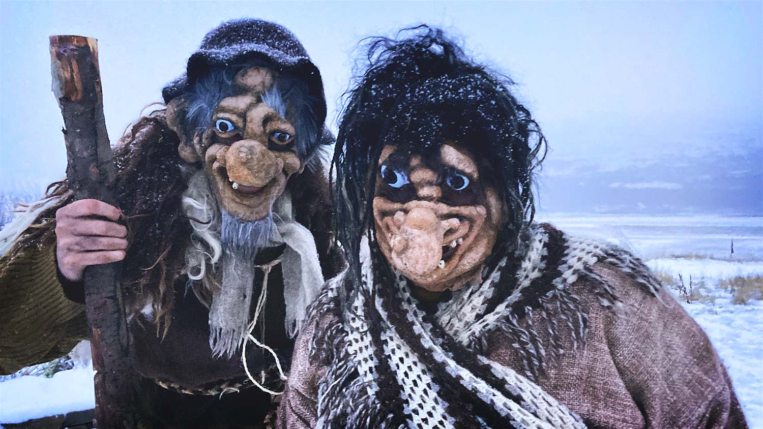 A couple of trolls in a snow landscape, one with a rod